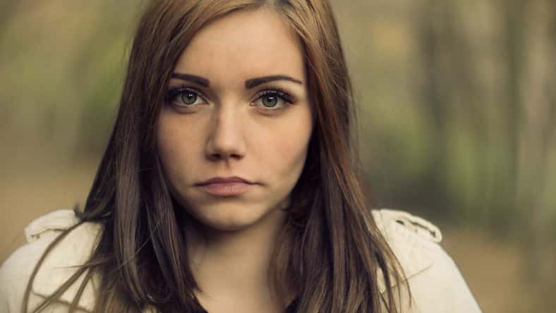 young woman portrait trees in the background