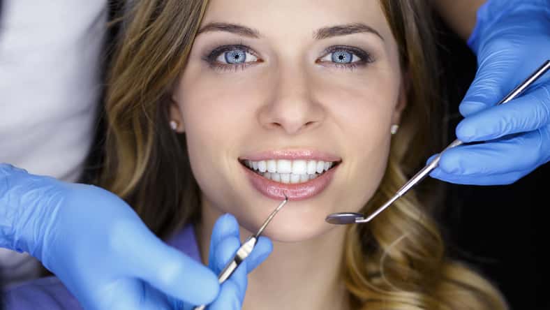 Girl with beautiful white teeth on reception at the doctor dentist.