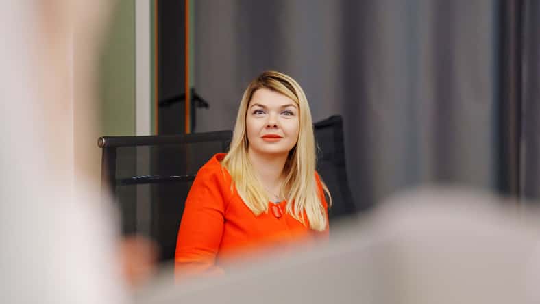 Attractive blonde woman in red dress listening to speaker at conference. organization of speeches for training and at seminars.