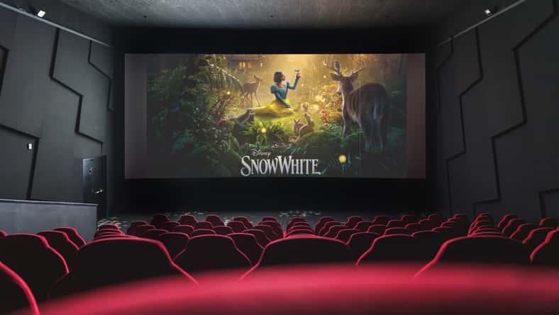 Movie theater screen displaying Disney Snow White film poster, viewed from empty red cinema seats. April 5, 2025