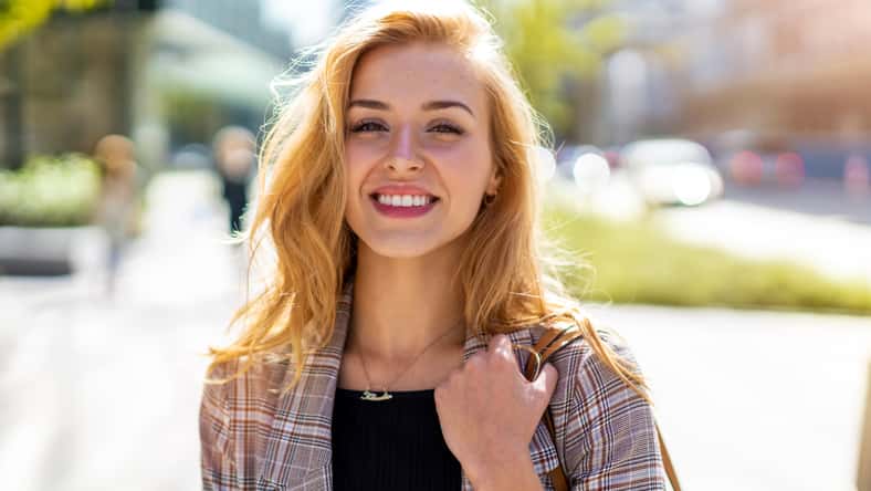 pretty woman smiling while outside in the summer