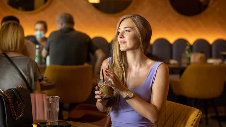 Attractive young woman holding iced coffee