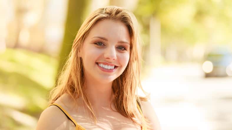 Happy smiling young woman outdoor. Pretty attractive girl portrait.