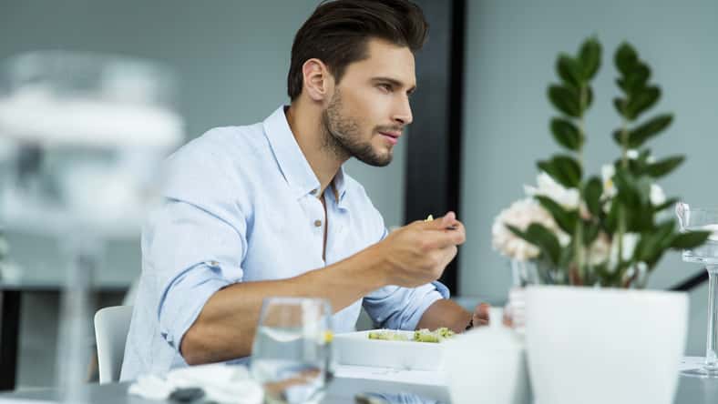 Handsome man eating meal