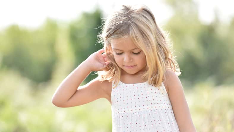 Portrait of cute little blond girl in countryside, summertime