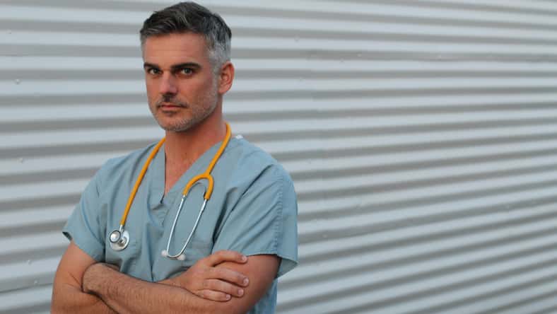 Mature handsome health care worker portrait isolated with arms crossed