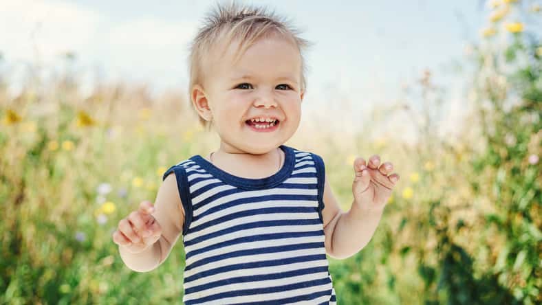 Funny little boy one year old, joyful summer portrait