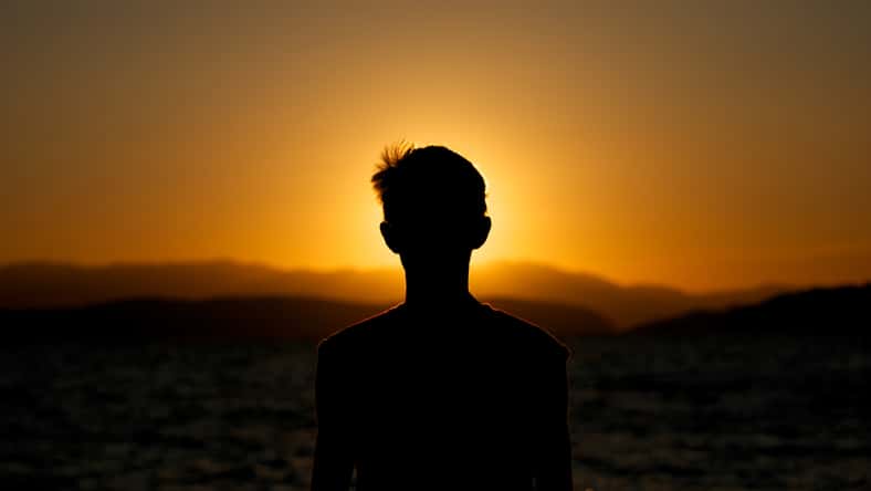 Fascination of silhouette of young boy on sunset
