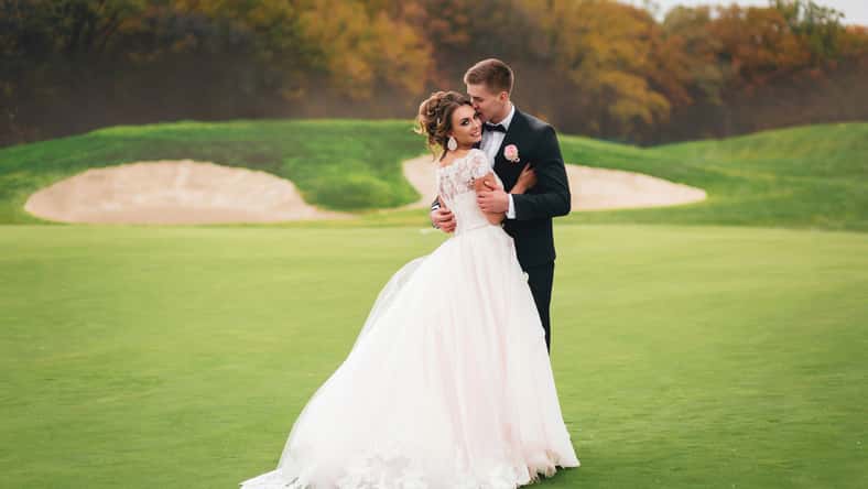 Beautiful bride and groom walking in Autumn Park