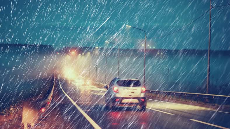 blurred background autumn auto rain on the road / night lights and raindrops in the autumn traffic jam on the road, urban style traffic