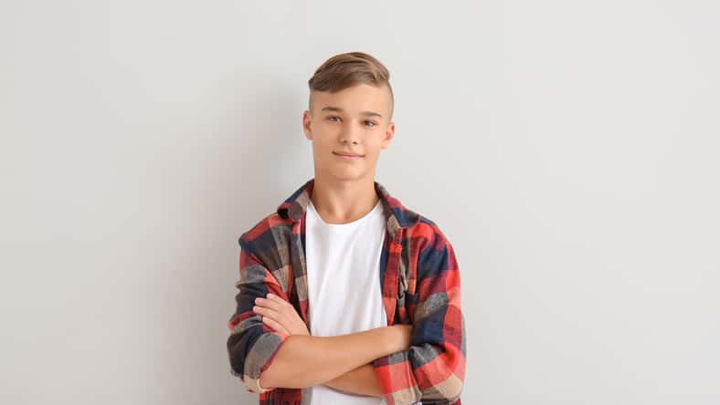 Confident teenage boy on white background