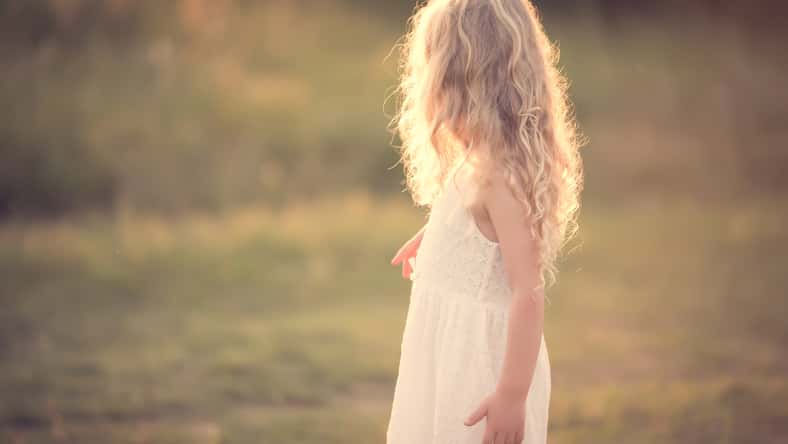 Beautiful blond little girl play in the field
