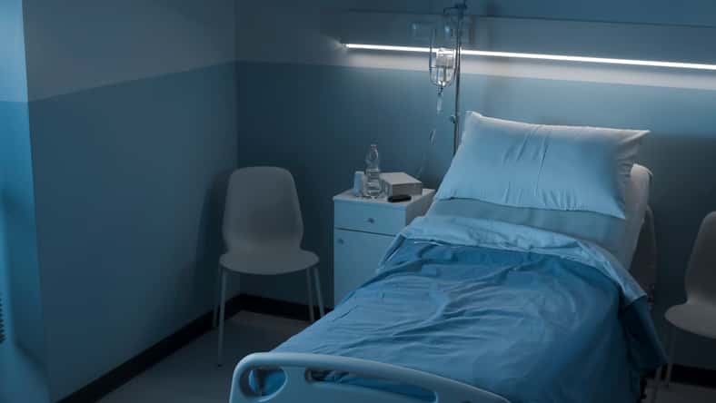 Clean hospital room interior at night with bed and medical equipment, medicine and healthcare concept