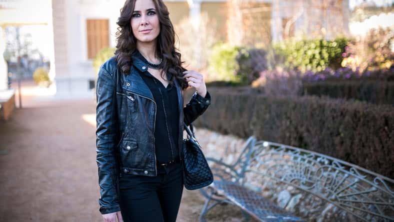 brunette woman dressed in black in a park