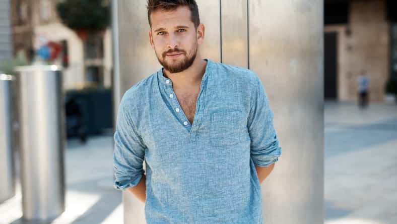Handsome man outdoor standing on city street waiting.
