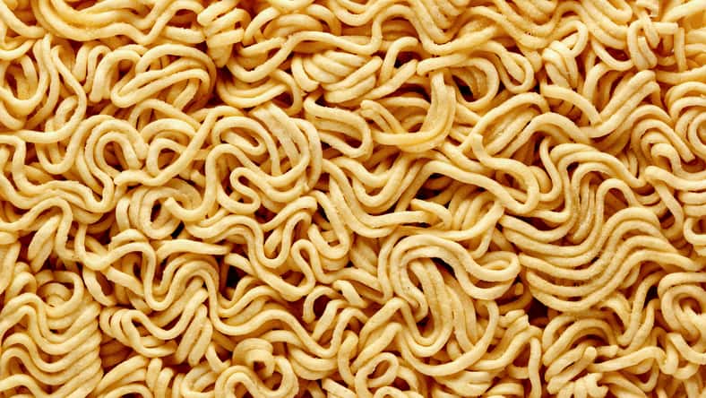 dry raw instant noodles, texture background top view.