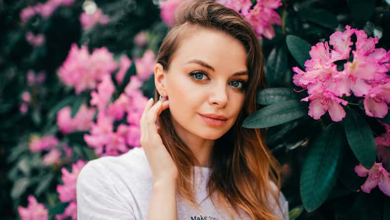 Young beautiful girl posing among the flowering tree