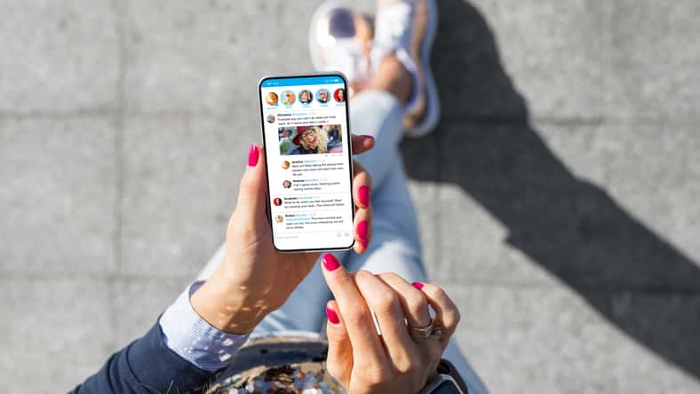 Woman using social media microblogging app on her phone