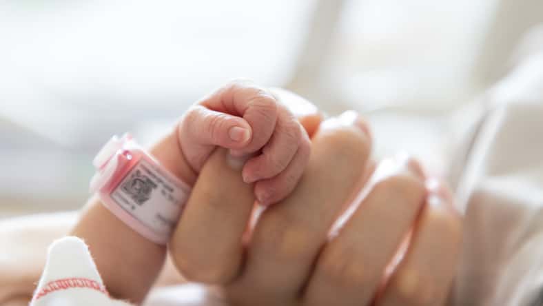 new born baby hand hold mum index finger. concept : Premature or preterm baby in hospital. relationship between mother and baby.