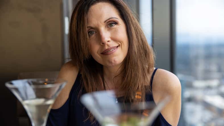 Pretty middle aged woman drinking a martini at a restaurant