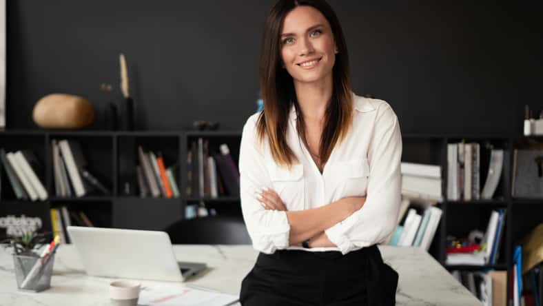 Confident stylish european middle aged woman standing at workplace. Stylish businesswoman, 30s lady executive leader manager looking at camera in office, portrait.