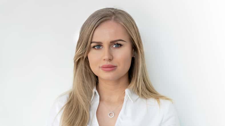 Blonde woman in white blouse. Smiling, confident, content, happy, pretty.
