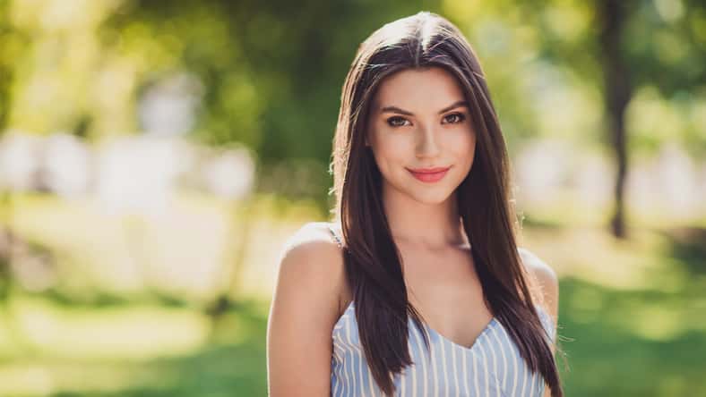 Photo of nice looking positive mood girl with long straight hairstyle go walk with friends outdoors in city park .