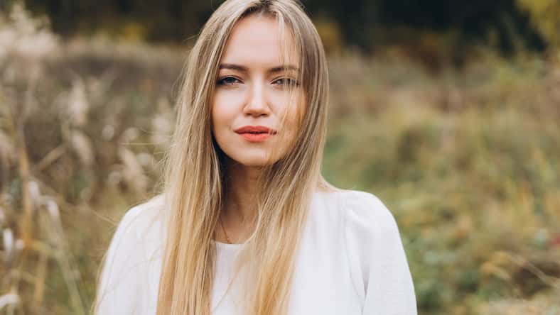 Outdoor atmospheric lifestyle portrait of young beautiful blondie lady. Warm autumn. Beautiful cheerful blondie woman