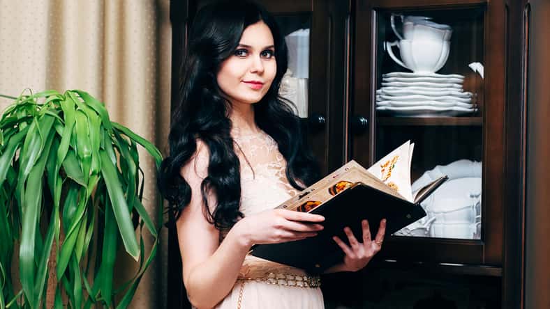 Girl hostess in a restaurant holding hands in the menu