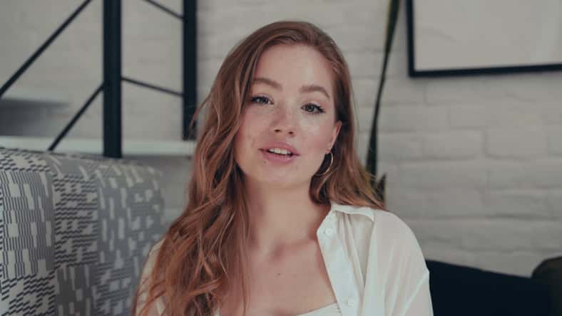 portrait-of-european-charming-redhead-young-woman-looking-at-camera-and-talking-over-v-SBI-351259683