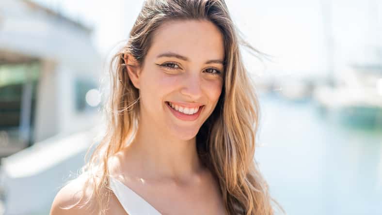 Young pretty woman at outdoors With cheerful expression