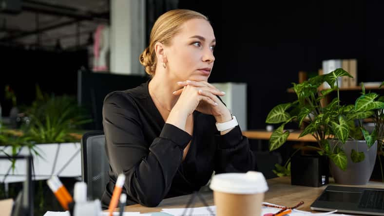A young beautiful plus size woman focuses intently while working at her office desk.