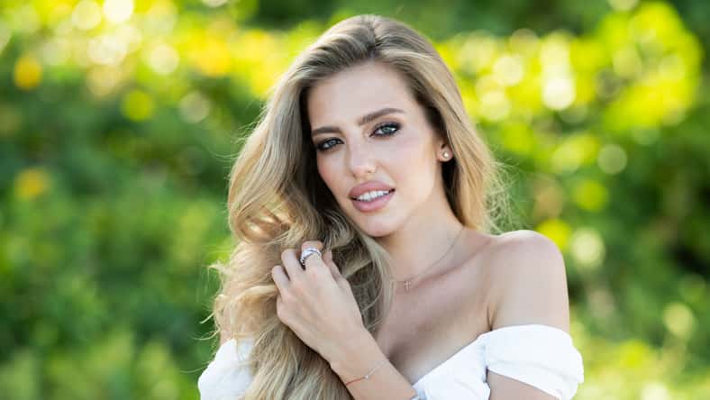 Beautiful woman enjoying spring. Attractive tender romantic girl on spring green nature background. Beautiful young woman with glamour make up outdoor portrait