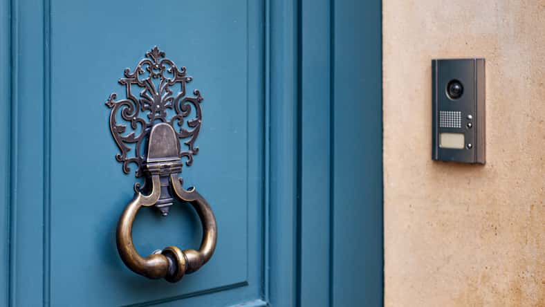 Old door knocker and modern doorbell