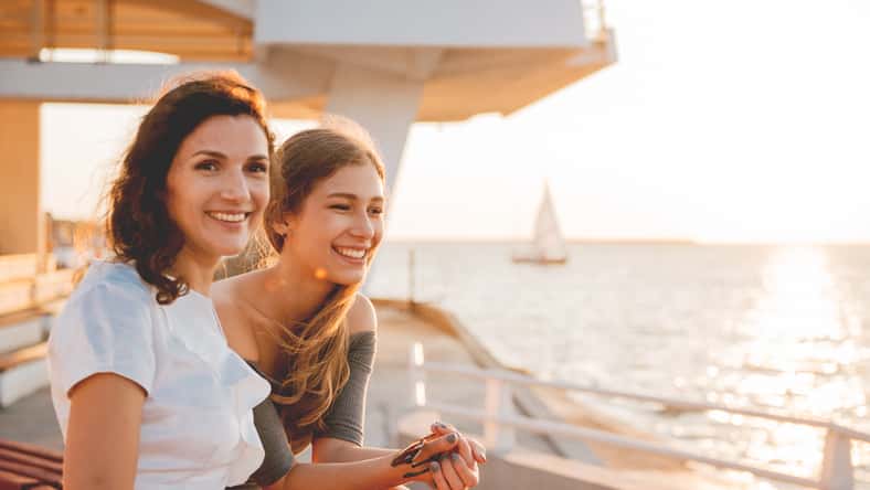 Close-up portrait of happy mother with a teenage daughter. Sunset light.