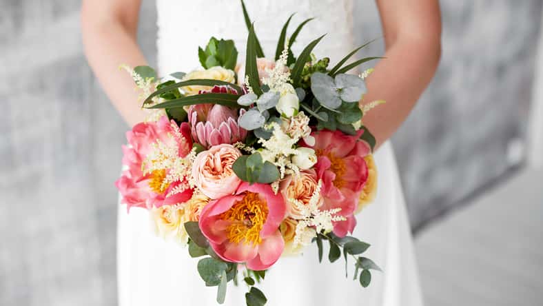 pink peony bouquet in hands of the bride