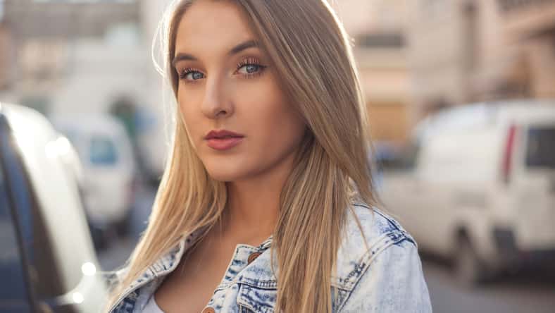 Beautiful blue eye model posing with narrow street in the background.