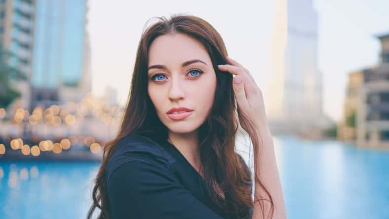 Close-up portrait of beautiful caucasian woman with charming smile and long hair walking on the Dubai street.
