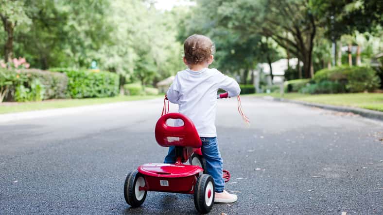 Young Child Toddler on Red Tricycle on a Neighborhood Street