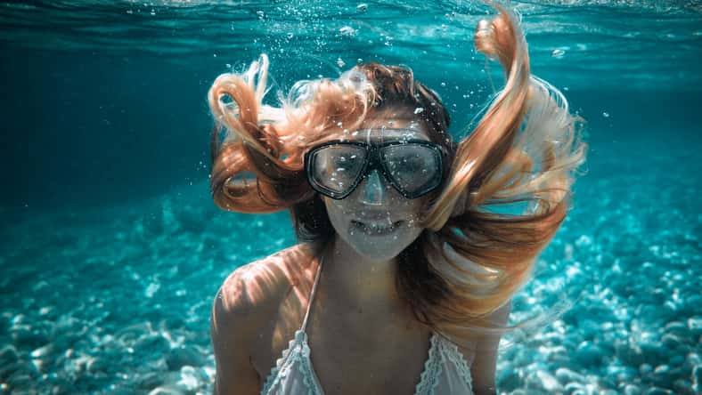 Beautiful woman with long hair underwater portrait in the tropical sea