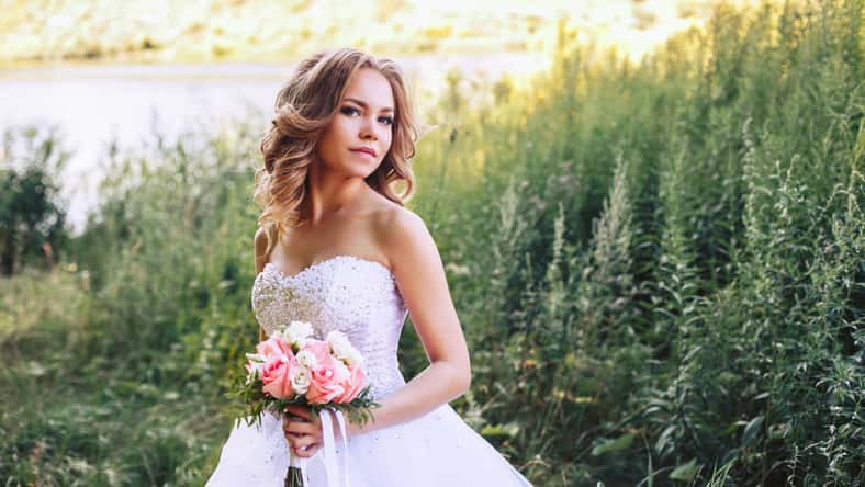 Photo of the bride in nature with a beautiful bouquet