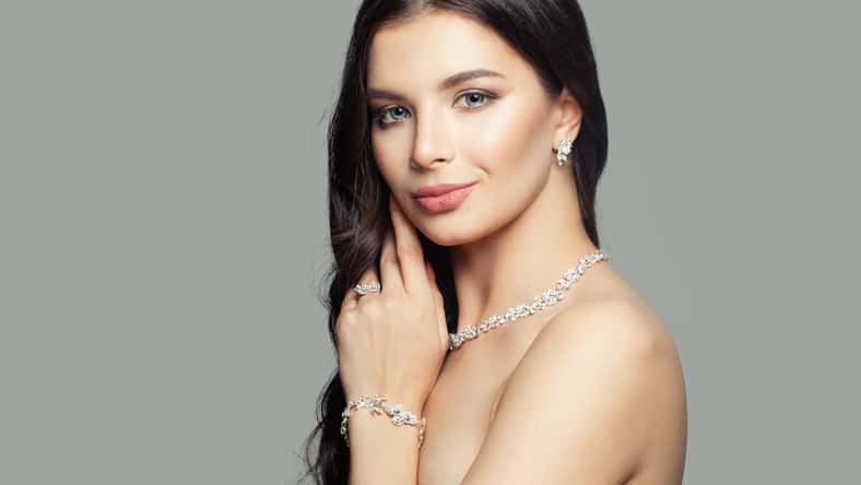 Beautiful woman with diamond ring, necklace, bracelet and earrings. Cute smiling girl