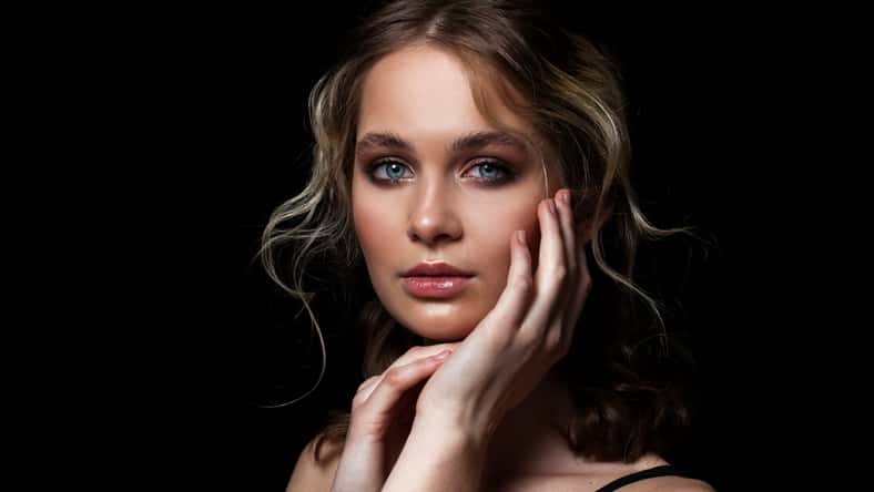Make up beauty. Close up beautiful blonde fashion model in studio portrait on black isolated background