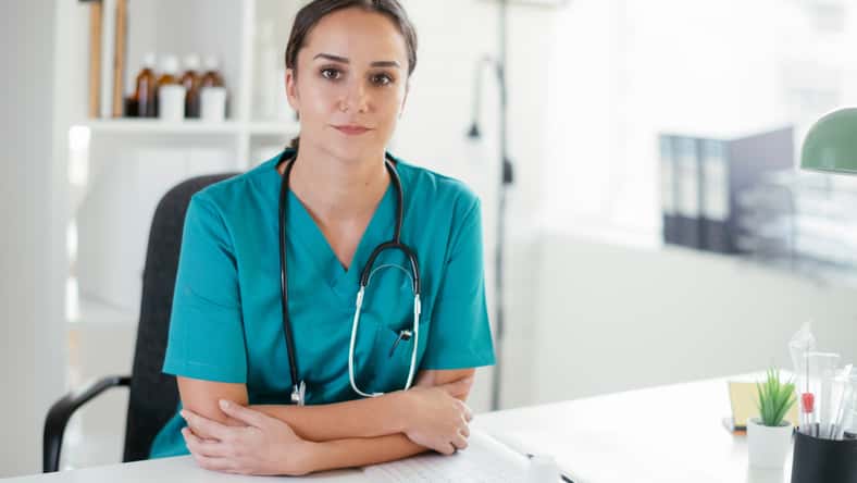 Young female doctor in medical office. Portrait of beautiful female doctor sitting in the clinic office.