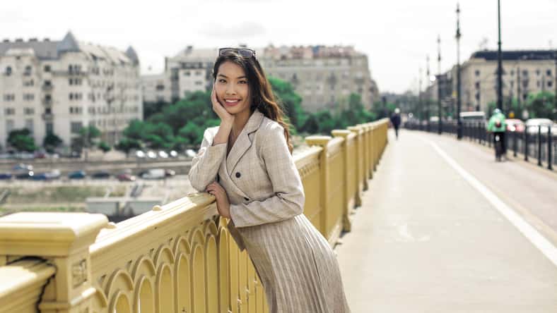 La mujer elegante camina por la ciudad