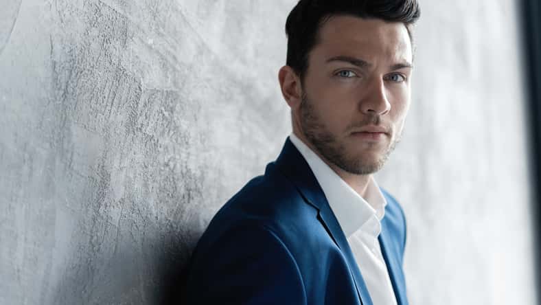 Handsome man wear blue suit isolated on grey background