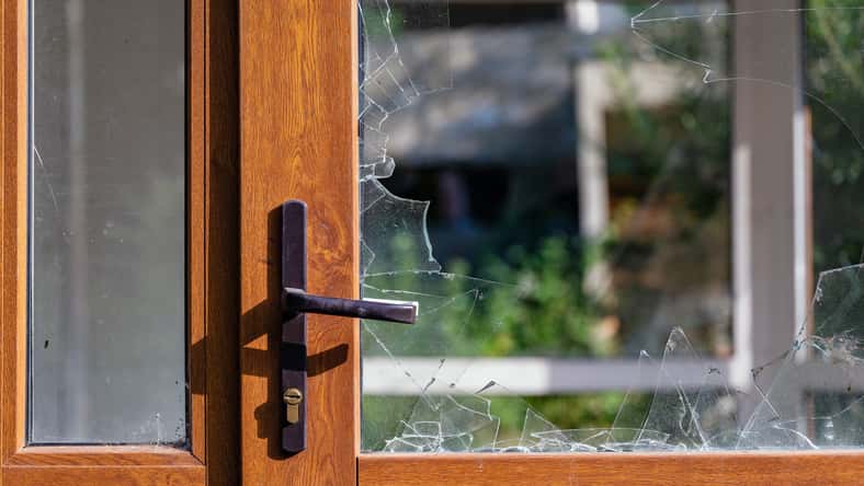 Modern door with handle and broken glass. Abandoned and dirty.