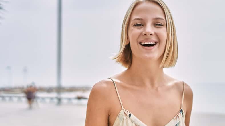 Young beautiful woman smiling confident by the sea