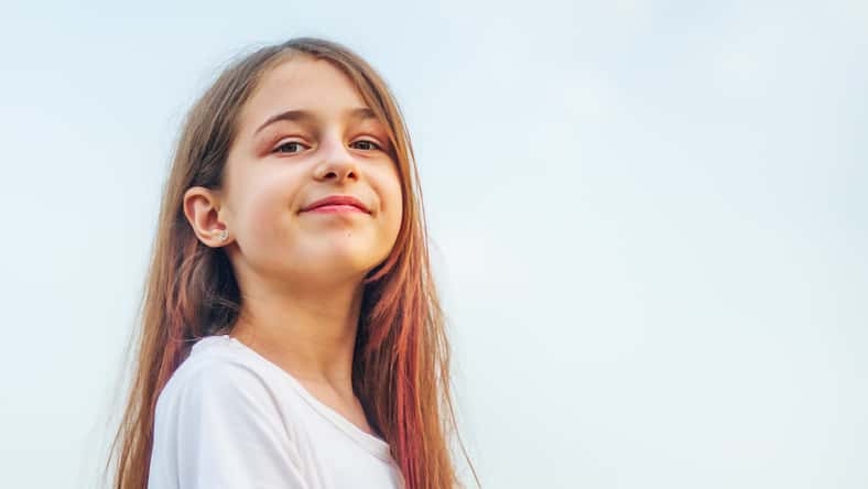 Niña 11 años. Retrato de una adolescente con el pelo largo contra el cielo.
