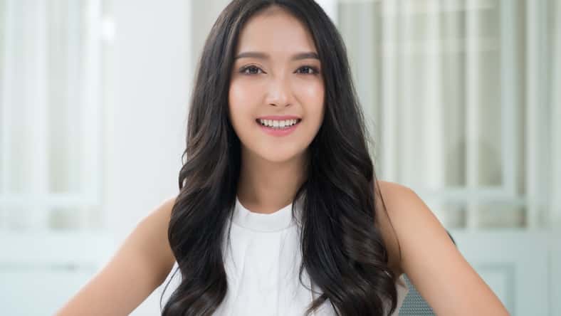 Close up portrait young Asian woman smiling in office
